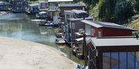 NIJMEGEN, NETHERLANDS - AUGUST 10: Boat houses are seen on the banks of the Waal River on August 10, 2022 in Nijmegen, Netherlands. The ongoing drought and the recurring heat waves have cut operation capacities by half along the lower Rhine from Rotterdam to Germany, an important coal transport route destined to steelmakers and power producers. (Photo by Pierre Crom/Getty Images)