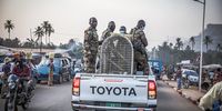 Members of the National Brigade for the Fight against Crime in Species of Wild Fauna and Flora in Guinea transport a cage holding a confiscated python. (Photo: Nathalie Bertrams) 