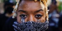 A woman with 'BLM' written on her cheek poses for a picture during a demonstration on May 31, 2020 in Atlanta, Georgia. Across the country, protests have erupted following the recent death of George Floyd while in police custody in Minneapolis, Minnesota. (Photo by Elijah Nouvelage/Getty Images)