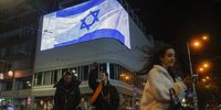 People walk past a giant screen displaying the Israeli national flag over a street in downtown Kyiv, Ukraine, 08 October 2023. Israeli flags appeared on digital street billboards in the Ukrainian capital as a show of solidarity with the Israeli people a day after rocket barrages were launched from the Gaza Strip in a surprise attack on Israel claimed by the Islamist movement Hamas. More than 670 Israelis were killed and over 2,100 left injured in the attacks, the Israeli army said 08 October 2023. According to the Gaza health ministry, 413 people were killed and 2,300 wounded following the Israeli airstrikes on Gaza.  EPA-EFE/SERGEY DOLZHENKO
