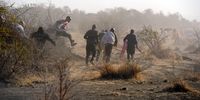 Miners fleeing while police fire live ammunition at the koppie outside nkaneng informal settlement near the Lonmin mine in Rustenburg (Photo: Felix Dlangamandla)