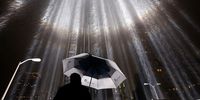 A worker holds an umbrella while adjusting beams of the Tribute in Lights ahead of the tenth anniversary of the September 11 terrorist attacks on September 7, 2011 in New York City. The Tribute in Light is comprised of 88 7000 watt searchlights that beam into the sky near the site of the World Trade Center in remembrance of the September 11 attacks. (Photo by Justin Sullivan/Getty Images)