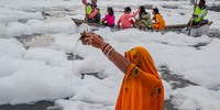 'Surya Argh'. A woman offers ‘Jal’ (water) to the sun, as she stands in the Yamuna river during Chhath Mahaparv. This series shares images from one of the biggest festivals celebrated in India: Chhath Mahaparv. It depicts the festival being celebrated in the sacred Yamuna river, which is now heavily polluted by acidic waste water spilling out from big factories. The pollution has made the water harmful to both flora and fauna. Image: © Sachin Ghai, India, Shortlist, Professional competition, Environment, Sony World Photography Awards 2024