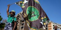 A supporter of the uMkhonto weSizwe Party holds a flag during a gathering ahead of the Constitutional Court issuing a ruling on whether former President Jacob Zuma could serve as a member of parliament, should his party win seats in the election less than three weeks away, in Johannesburg, South Africa, May 10, 2024. REUTERS/Siphiwe Sibeko