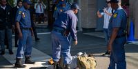 Climate activist Angelo Doyle lying on the ground after being dragged through a barricade by SAPS officers outside the Standard Bank Rosebank offices in Johannesburg. (Photo: Julia Evans)