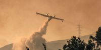 A firefighting plane makes a water drop as a wildfire burns in the village of Gennadi, on the island of Rhodes, Greece, July 25, 2023. REUTERS/Nicolas Economou     TPX IMAGES OF THE DAY