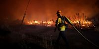 JANESVILLE, CALIFORNIA - AUGUST 16: A firefighter pulls a hose while monitoring the Dixie Fire as it burns close to a home on August 16, 2021 near Janesville, California. The Dixie Fire has burned over 578,000 acres, has destroyed over 1,000 homes and threatens thousands more. The fire, the largest single fire in California state history, is 31 percent contained. (Photo by Justin Sullivan/Getty Images)