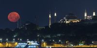 A full moon sets behind the Blue Mosque and the Hagia Sophia Grand Mosque, in Istanbul, Turkey, 03 July 2023.  EPA-EFE/ERDEM SAHIN