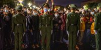 BEIJING, CHINA - OCTOBER 01: Police officers stand as they perform crowd control as people attend an official flag raising ceremony to mark National Day next to Tiananmen Square and the Forbidden City on October 1, 2021 in Beijing, China. China is celebrating their 72nd National Day and a week-long holiday known as the "Golden Week". (Photo by Kevin Frayer/Getty Images)