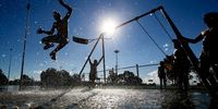 Local children play on a swing set partially submerged flood water in the suburb of Riverstone in Sydney, Australia, on Wednesday, March 24, 2021. European coal prices traded higher in March, squeezed by shrinking reserves and flood-related supply disruptions in Australia. Photographer: Brendon Thorne/Bloomberg via Getty Images