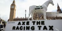 LONDON, ENGLAND - SEPTEMBER 10: A model race horse with the statement "#Axe the racing tax" is displayed outside the Houses of Parliament on September 10, 2025 in London, England. British Racing has cancelled all horse racing meets tomorrow in support of the 'Axe The Race Tax' movement hoping to persuade the government not to include horse racing betting in their gambling tax simplification plans. Jockeys including Hollie Doyle, Tom Marquand, Saffie Osborne, Kieran Shoemark, Lily Pinchin, Richard Johnson, Oisin Murphy, Harry Cobden and Paul O'Brien were to take part. (Photo by Dan Kitwood/Getty Images)