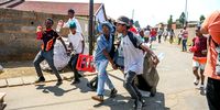 Community members loot from spaza shops in Naledi on 9 October (Photo: Sharon Seretio /  Gallo Images)