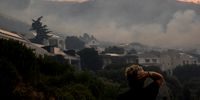 Residents stand in Cornwall Street and watch in shock as the fire burns quite closely to the houses within the neighbourhood of Simons Town. 19 December 2023. (Photo: Kyra Wilkinson)