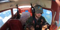 Democratic Republic of Congo, Bukavu: Virunga National Park pilot Anthony Caere flies two rescued baby chimps to Lwiro Primates Rehabilitation center. These babies are survivors of the illegal bushmeat trade and were rescued by Congolese conservation investigators. Their mothers were killed and their meat sold by hunters who then tried to sell the babies as pets. Once at the center, the babies will be cared for like human children by keepers in a house, easing their trauma and preparing them to join the other rescued chimps in the santuary. © Brent Stirton, South Africa, Shortlist, Professional, Wildlife & Nature, 2021 Sony World Photography Awards