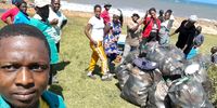 Cromwell Sonjica (left) and colleagues from the Mtentu area pile up bags of trash following a beach clean-up. (Photo: Supplied)