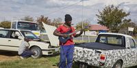 Thulani, street side mechanic and aspiring musician, plays his guitar through an amplier in the back of his truck, during the coronavirus lockdown, Diepkloof, Soweto, South Africa, 26 April 2020