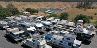 In an aerial view, houseboats sit in the Bidwell Canyon Marina parking lot at Lake Oroville on June 01, 2021 in Oroville, California. As water levels continue to fall at Lake Oroville, officials are flagging houseboats that are anchored on the lake for removal to avoid being stuck or damaged. Lake Oroville is currently at 38 percent of normal capacity. According to the U.S. Drought Monitor, 16 percent of California is in exceptional drought, the most severe level of dryness. (Photo by Justin Sullivan/Getty Images)