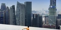 A guest swims in the Skypark pool atop Las Vegas Sands Corp.'s Marina Bay Sands integrated resort and casino in Singapore, on Wednesday, July 28, 2010. Singapore's government, which has to hold an election by 2012, may find that record economic growth isn't enough to keep citizens happy as the nation turns 45. Photographer: Munshi Ahmed/Bloomberg via Getty Images