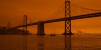A ship passes beneath the Bay Bridge as smoke from various wildfires burning across Northern California mixes with the marine layer, blanketing San Francisco in darkness and an orange glow on September 9, 2020 in San Francisco, California. Over 2 million acres have burned this year as wildfires continue to burn across the state. (Photo by Philip Pacheco/Getty Images)