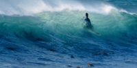 Surfer swims through a wave at Pringle Bay.