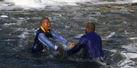 Bishop Vukani Ndlela and Bishop Thembinkosi Makhathini of the uKukhanya kuka Jehova Church say prayers before baptising their congregants. They held hands and dipped themselves under water before calling each congregant one by one. Photo: Felix Dlangamandla
