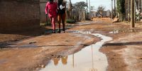 Sewage streams down an unpaved road in Finetown North. (Photo: Kabelo Mokoena)