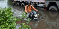 A motorcyclist drives through a flooded street in New Delhi, India, on Thursday, July 13, 2023. Torrential rain in northern India has pushed water levels to an all-time high in the Yamuna, a major river that cuts through the capital Delhi, leading to evacuations in some areas. Photographer: Prakash Singh/Bloomberg via Getty Images