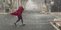 JOHANNESBURG, SOUTH AFRICA - JULY 10: People walk in the snow in Newtown on July 10, 2023 in Johannesburg, South Africa. It is reported that the South African Weather Service (SAWS) warned that snow comes with very cold conditions expected to last until the end of the week. (Photo by Gallo Images/Alet Pretorius)