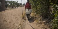 Martin Matanye  as he makes his way back home after filling his containers with water. Matanye spend more then an hour waiting for his containers to fill due to low pressure from a single tap that serves as a communal tap. (Photo: Shiraaz Mohamed)