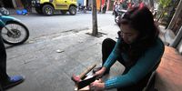 A traditional Chinese medicine dealer in Hanoi, Vietnam, hacks <br>off rhino-horn portions on her shop pavement.