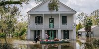 People wade through water on August 31, 2021 in Barataria, Louisiana. Many shops, stores, and services are closed as power throughout New Orleans and its surrounding region is down. Ida made landfall as a Category 4 hurricane on August 29 in Louisiana and brought flooding and wind damage along the Gulf Coast. (Photo by Brandon Bell/Getty Images)