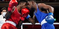 Cameroons Albert Mengue Ayissi, left, exchanges punches with Switzerlands Thabiso Dlamini during their mens welterweight 69-kg boxing match at the Tokyo 2020 Olympics July 24, 2021 in Tokyo, Japan. (Photo by Frank Franklin II - Pool/Getty Images)
