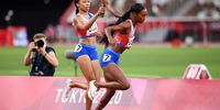 TOKYO, JAPAN - AUGUST 07: Allyson Felix of Team United States passes the baton to teammate Dalilah Muhammad in the Women' s 4 x 400m Relay Final on day fifteen of the Tokyo 2020 Olympic Games at Olympic Stadium on August 07, 2021 in Tokyo, Japan. (Photo by Matthias Hangst/Getty Images)