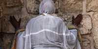 epa09169209 An Orthodox Christian worshipper prays outside the Church of the Holy Sepulture during a Good Friday procession on the Via Dolorosa in Jerusalem's Old City, 30 April 2021. Pilgrims retraced the route taken by Jesus Christ to his crucifixion through the alleys of Jerusalem. The week of 25 April thru 02 May, about 300 million Orthodox Christians worldwide observe the Holy Week.  EPA-EFE/ATEF SAFADI