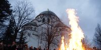 epa09670190 People watch the ceremonial burning of dried oak branches, a Yule log symbol for the Orthodox Christmas Eve in front of the Saint Sava temple in Belgrade, Serbia, 06 January 2022. Christian Orthodox believers who follow the Julian calendar will celebrate Christmas on 07 January.  EPA-EFE/ANDREJ CUKIC