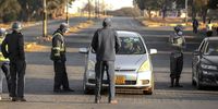 Zimbabwe Republic Police enforcing lockdown regulations at a checkpoint on a street in in the township of Mbare in Harare on 31 July 2020. (Photo Stringer)