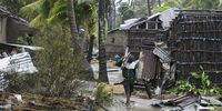 A man collects wood on a flooded street near Quelimane, as the storm Freddy hits Mozambique, 12 March 2023. (Photo: EPA-EFE / Andre Catueira) 