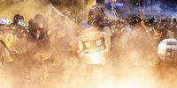 Riot police officers are englufed by tear gas during an anti-extradition bill protest, in Hong Kong, China, 04 August 2019. Declassified was unable to get a comment from the MOD about British army training of Hong Kong police. (Photo: EPA-EFE / Chan Long Hei)