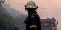 A firefighter watches briefly, before heading to help his team put out the fire which broke out near Barnard street. 19 December 2023. (Photo: Kyra Wilkinson)