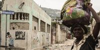 A pedestrian crosses a street littered with trash in the Martissant neighborhood of Port-au-Prince, Haiti, on Tuesday, Aug. 17, 2021. The poorest nation in the Western Hemisphere, Haiti has been struggling with food shortages, widespread violence and political chaos in the wake of the murder of President Jovenel Moise last month. Photographer: Jonathan Alpeyrie/Bloomberg via Getty Images