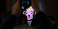 NEW YORK, NEW YORK - MARCH 21: A guest takes a photo during Christie's announcement that they will offer Andy Warhol’s Shot Sage Blue Marilyn painting of Marilyn Monroe at Christie’s on March 21, 2022 in New York City. The work comes to Christie’s from the Thomas and Doris Ammann Foundation Zurich and all proceeds of the sale will benefit the foundation. (Photo by Dia Dipasupil/Getty Images)