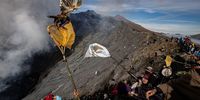 PROBOLINGGO, JAVA, INDONESIA - JUNE 26: An Indonesian man catches a chicken thrown by Hindus Tenggerese worshippers at Mount Bromo during the Yadnya Kasada ritual on June 26, 2021 in Probolinggo, Java, Indonesia. The Tenggerese people are an ethnic group in Eastern Java, Indonesia's most populous island, who believe themselves to be descendants of the Majapahit princes that ruled the area historically. Their population of roughly 500,000 is centered in the Bromo Tengger Semeru National Park in eastern Java. The ethnic group's most popular ceremony, the month-long Yadnya Kasada festival, was the most visited tourist attraction in Indonesia before the Covid-19 pandemic. On the fourteenth day, the Tenggerese make a journey to Mount Bromo to make offerings of rice, fruits, vegetables, flowers and even livestock and poultry, throwing them into the volcano's caldera. The ritual is thought to have started in the 15th century, when a local princess and her husband prayed to the mountain gods for help in having children. (Photo by Robertus Pudyanto/Getty Images)