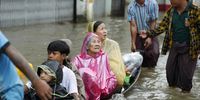 Volunteers use a boat to evacuate elderly people and children during a flood in Bago, Myanmar, 10 October 2023. Heavy monsoon rains have caused floods and landslides in Myanmar.  EPA-EFE/NYEIN CHAN NAING