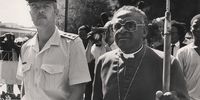 JOHANNESBURG, SOUTH AFRICA - May 2, 1986: An SAP officer escorts Bishop Tutu to the officer in command in Vredefort to confirm Bishop Ndwandwe. (Photo by Gallo Images / Business Day / Walter Dhladhla)