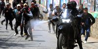 A police officer sprays pepper gas during a day of protests by public transport drivers, in La Paz, Bolivia, 23 October 2024. The transport unions of La Paz are carrying out a strike to demand that the Government guarantees the supply of fuel, affected by the blockades maintained by sectors related to former president Evo Morales. The transporters blocked the highway between La Paz and El Alto, so the Police had to intervene to clear the road with tear gas, while the protesters threw stones at the agents.  EPA-EFE/Luis Gandarillas