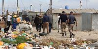 Officials walking past rubbish piling up next to homes during the walkabout in Philippi East. (Photo: Velani Ludidi)