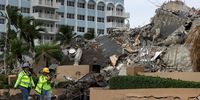 SURFSIDE, FLORIDA - JULY 06: Workers helping with the search and rescue walk along Collins Avenue past the completely collapsed 12-story Champlain Towers South on July 6, 2021 in Surfside, Florida. The portion of the building left standing after the deadly June 24 collapse was demolished Sunday night ahead of the approach of Tropical Storm Elsa. Officials say the death toll climbed to 36 today, with 109 still unaccounted for.  (Photo by Joe Raedle/Getty Images)