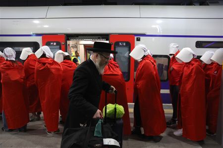 In images: Women in 'Handmaid's Tale' costume ride a train during an anti-government protest in Jerusalem