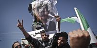 Palestinian students burn a poster depicting Syrian President Bashar Assad during a demonstration against his regime at the Unknown Soldier Square in Gaza City on 21 February 2012. (Photo: EPA / Ali Ali)