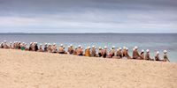 PERTH, AUSTRALIA - MARCH 04: Participants take part in a group meditation session as part of a surrealist art installation at North Cottesloe beach on March 04, 2021 in Perth, Australia. The human installation coordinated by surrealist artist Andrew Baines is to highlight the work of "Meeting for Minds" an international organisation that deals with mental health, aimed at helping the community deal with the ongoing pandemic in a meditative way. (Photo by Paul Kane/Getty Images)